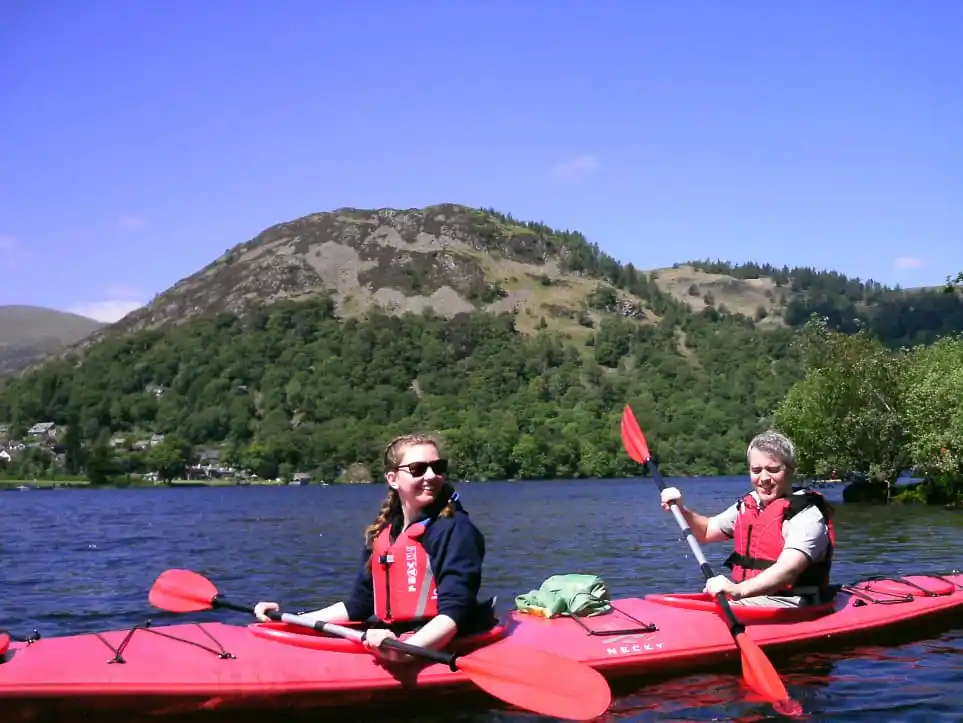 A couple enjoying a kayak tour on Ullswater in The Lake District.