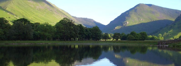 Serene view of Brotherswater reflecting the surrounding Lake District mountains at sunrise