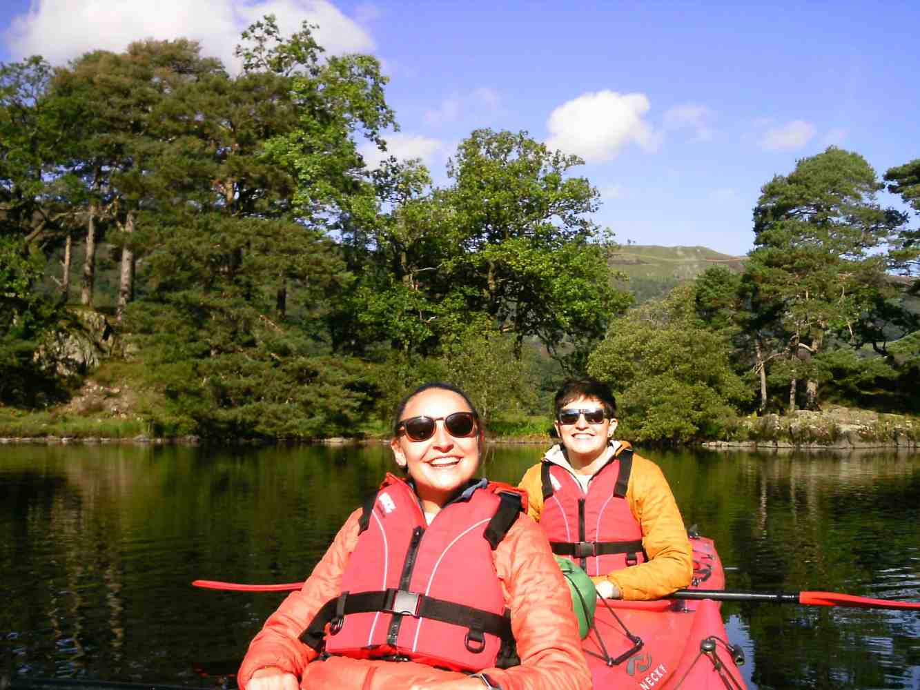 A couple enjoying a guided kayak tour on Ullswater in The Lake District.