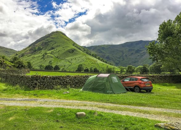 Sykeside Camping Park A car parked in a grassy field with a mountain in the background