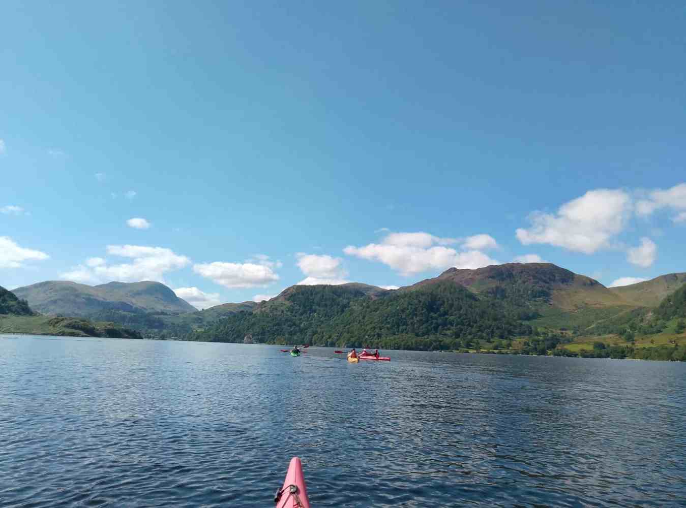 A group of friends kayaking on Ullswater on a beautiful sunny day in The Lake District